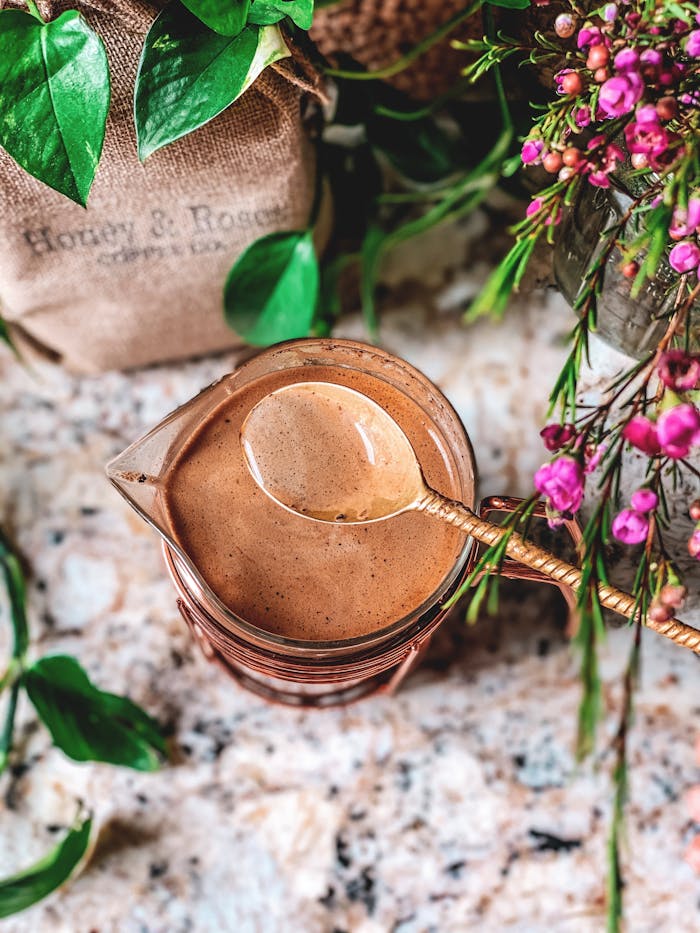 Rustic coffee setting with Honey & Roses coffee, flowers, and spoon.